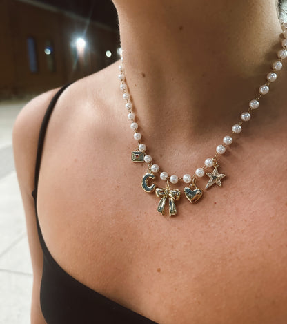 Necklace with various charms worn by a person outdoors at night.