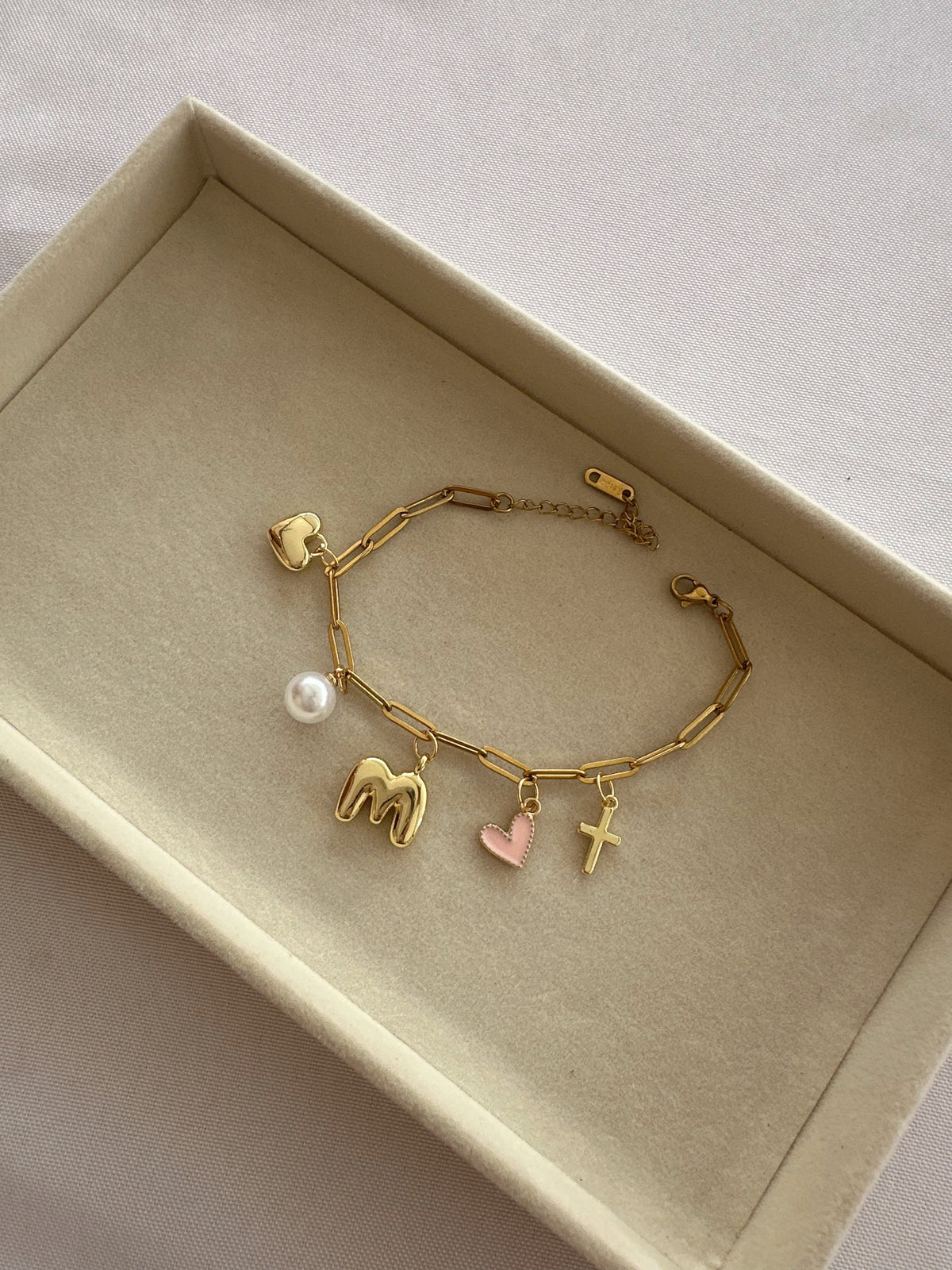 Gold bracelet with various charms in a box