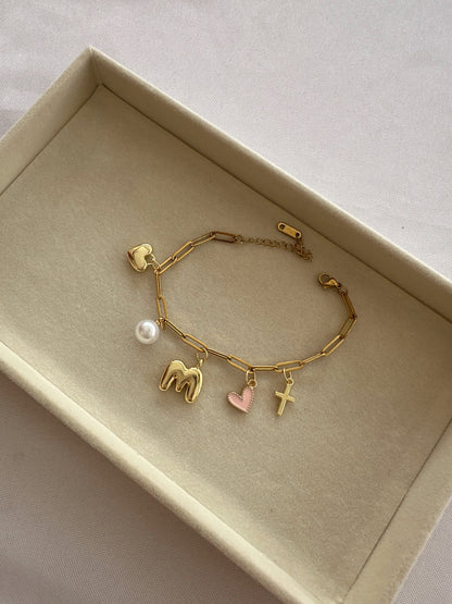 Gold bracelet with various charms in a box
