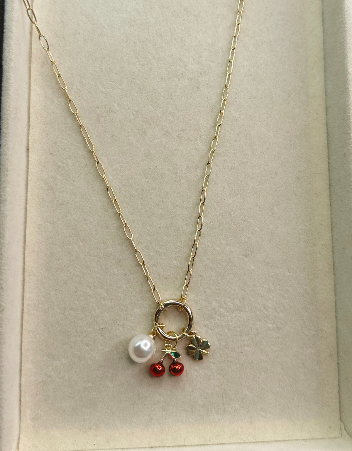 Necklace with a pearl and cherry pendant on a light background