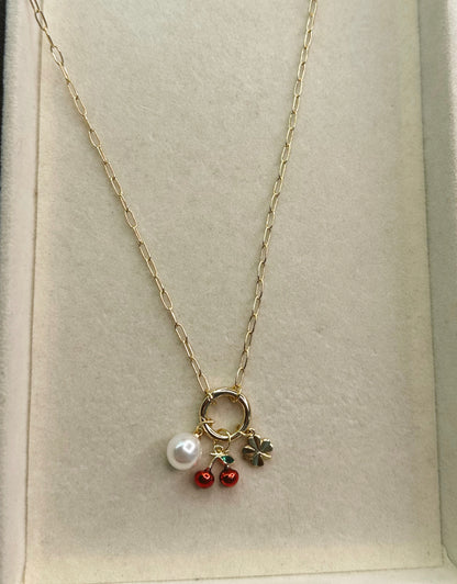 Necklace with a pearl and cherry pendant on a light background